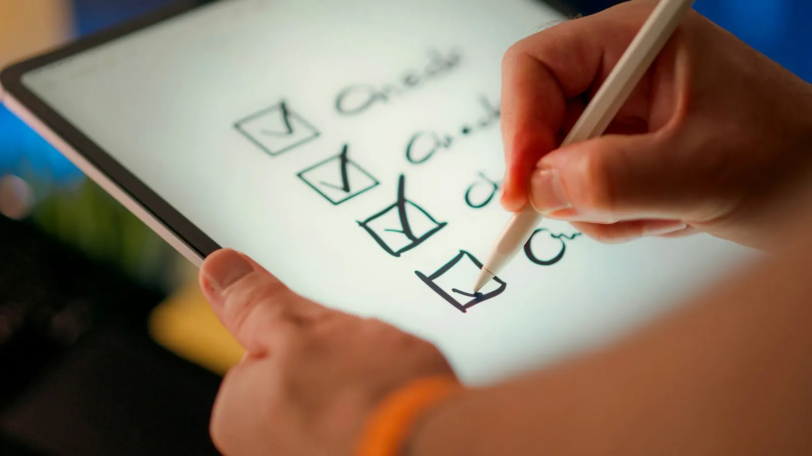 A hand with a stylus ticking off a checklist on a tablet screen.