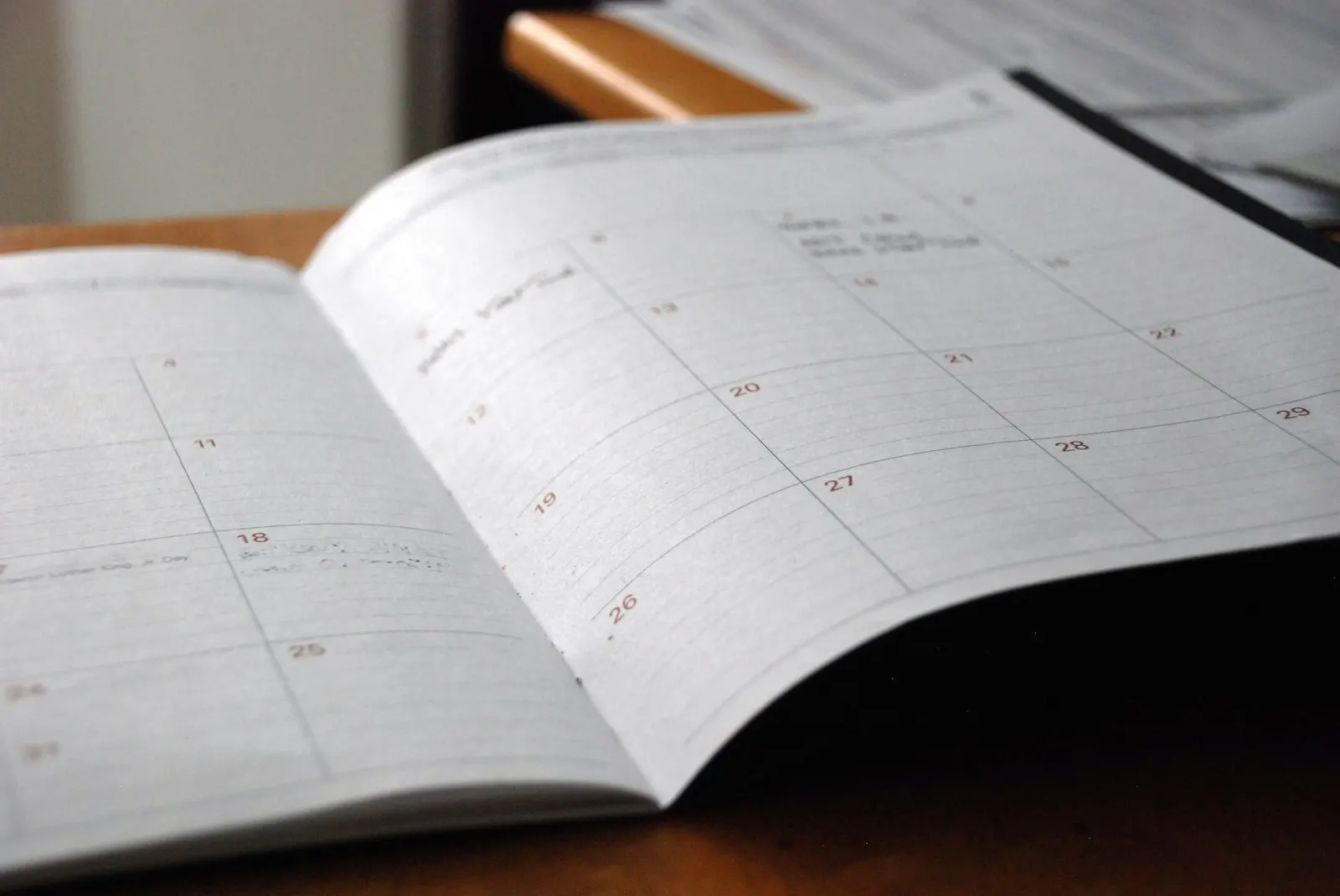 An open monthly planner on a wooden desk.
